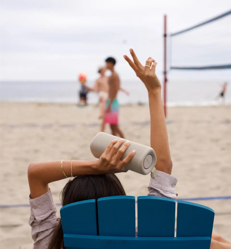 Woman lounging on the beach with her Bluetooth Speaker