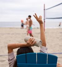 Woman lounging on the beach with her Bluetooth Speaker
